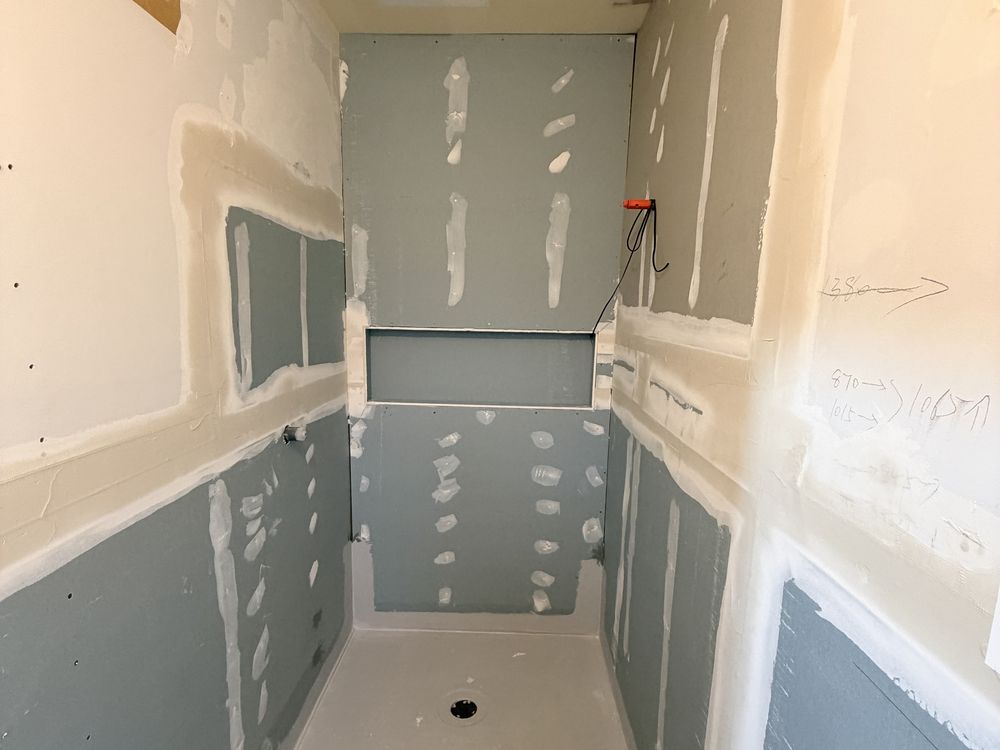 Waterproofing membrane applied to bathroom walls and floor before tiling