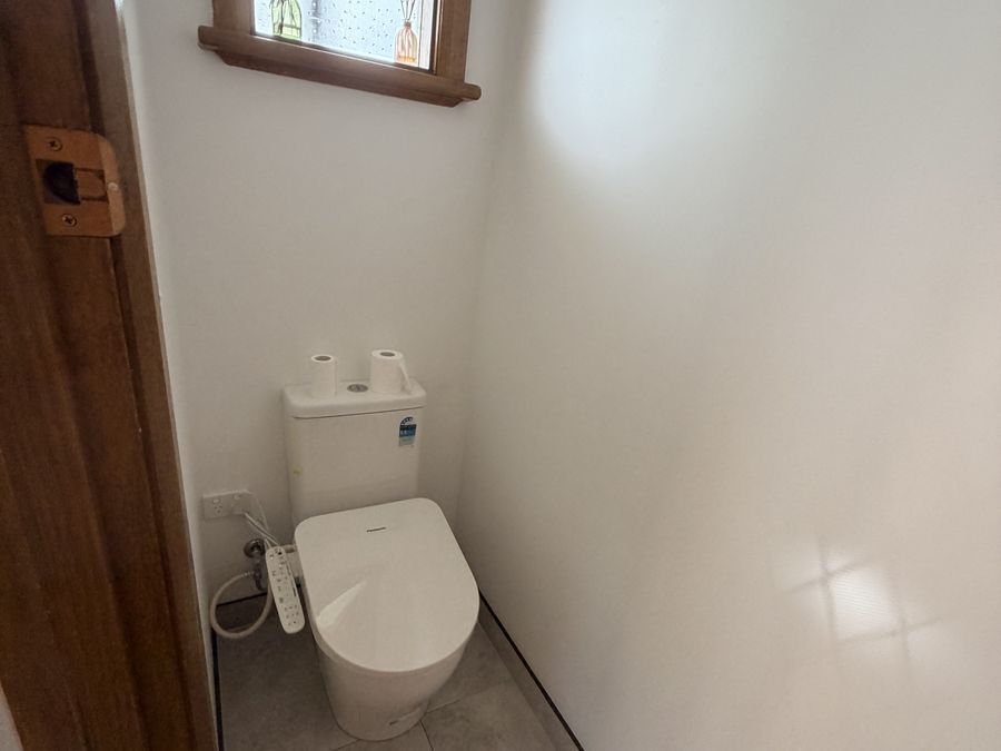 Separate toilet with wall-hung pan and large format tiles